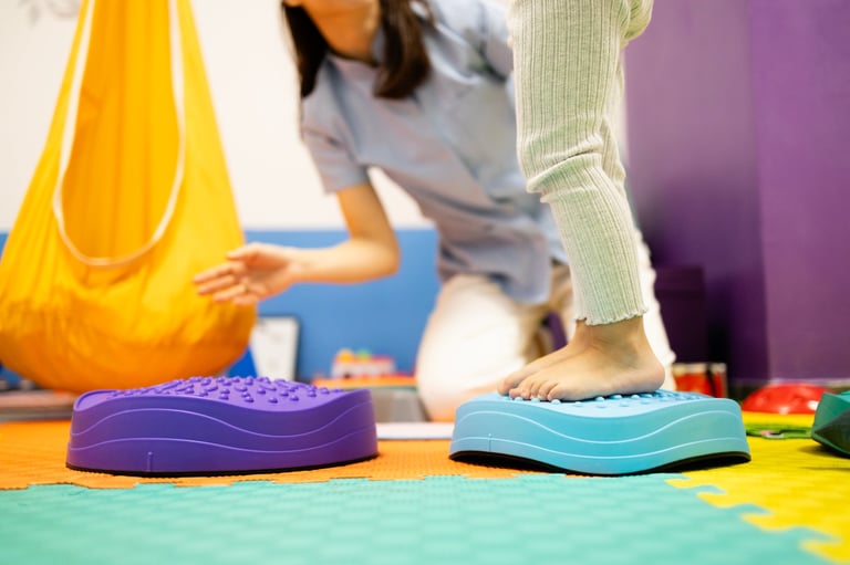 Patient improving balance and motor skills during a rehabilitation session with a specialist in a therapy room